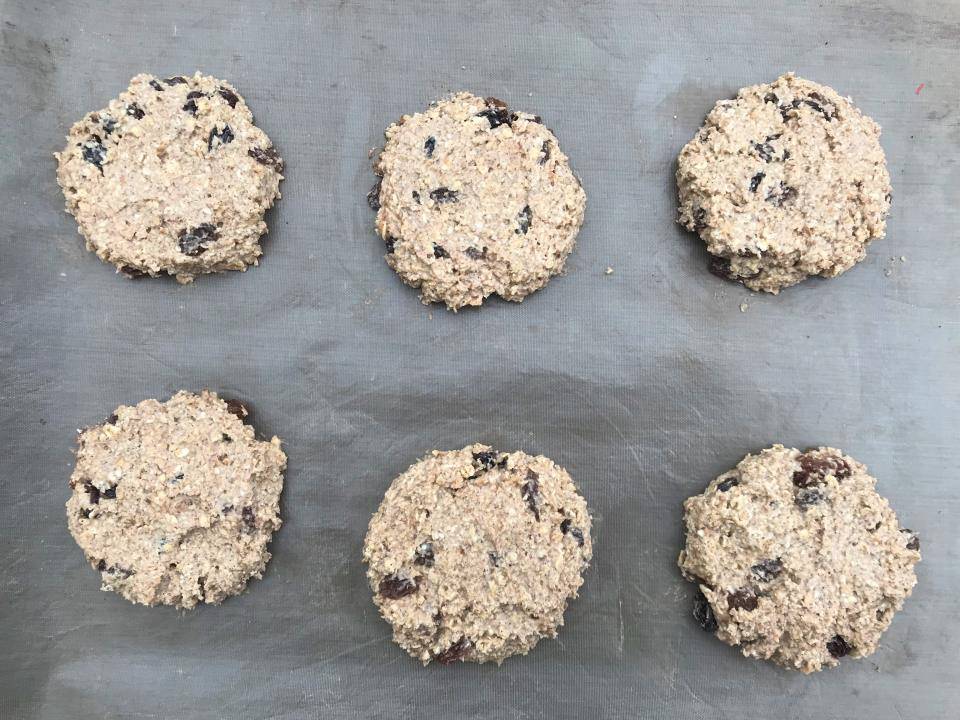 Raw healthy oat and raisin cookies on tray