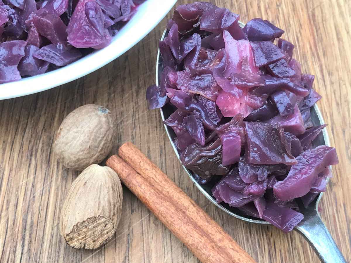 Easy braised red cabbage on spoon and in dish with nutmeg and cinnamon.