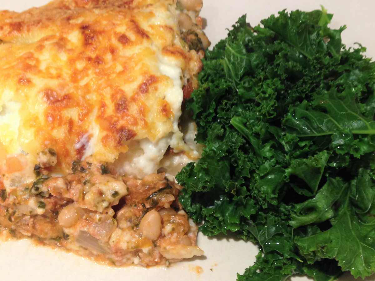 Plate of easy, healthy lasagne (with 2 portions of veg) served with kale