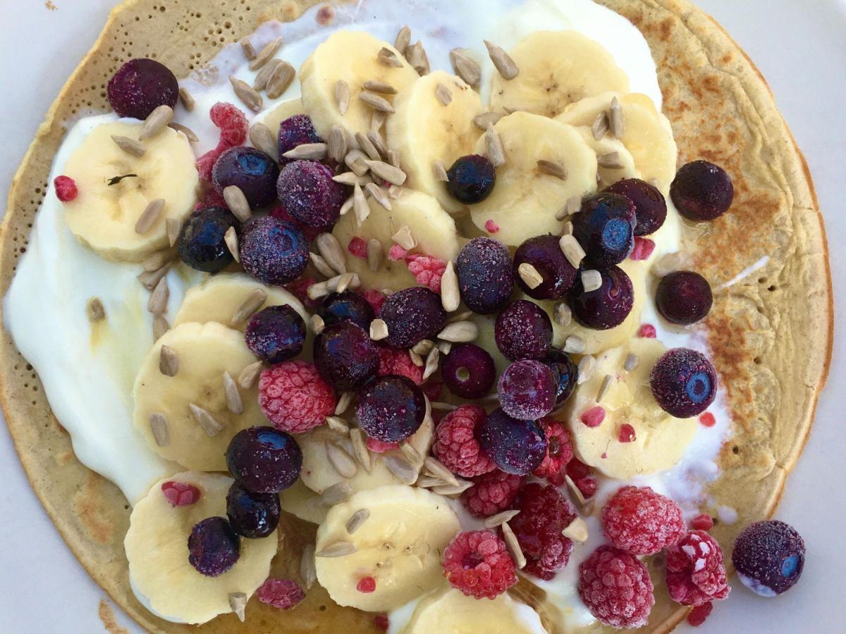 Oat flour pancakes topped with fruit and yogurt