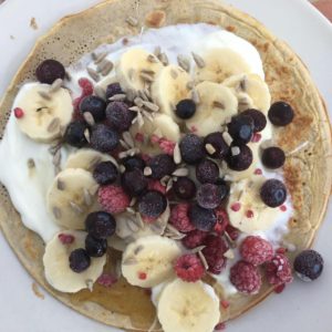 Oat flour pancakes topped with fruit and yogurt