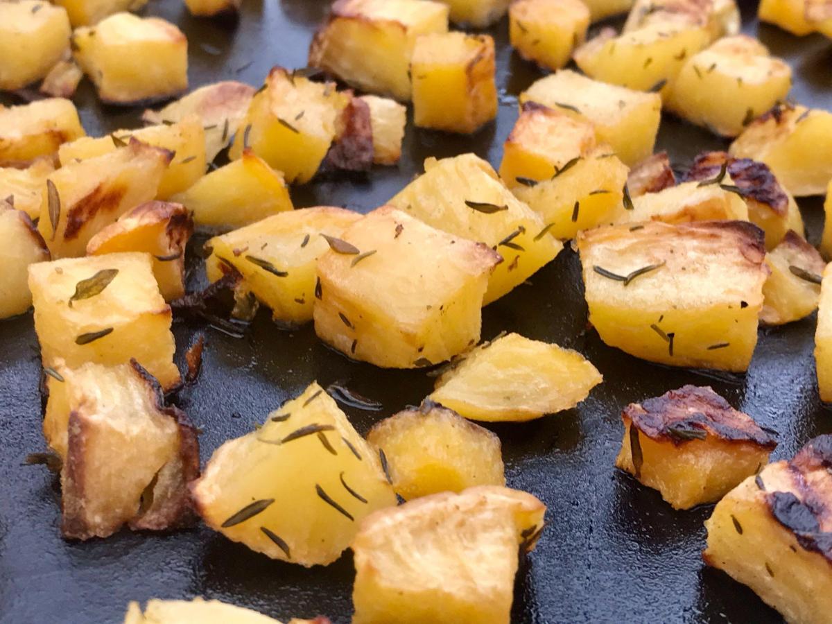 Roasted swede with herbs on baking tray.