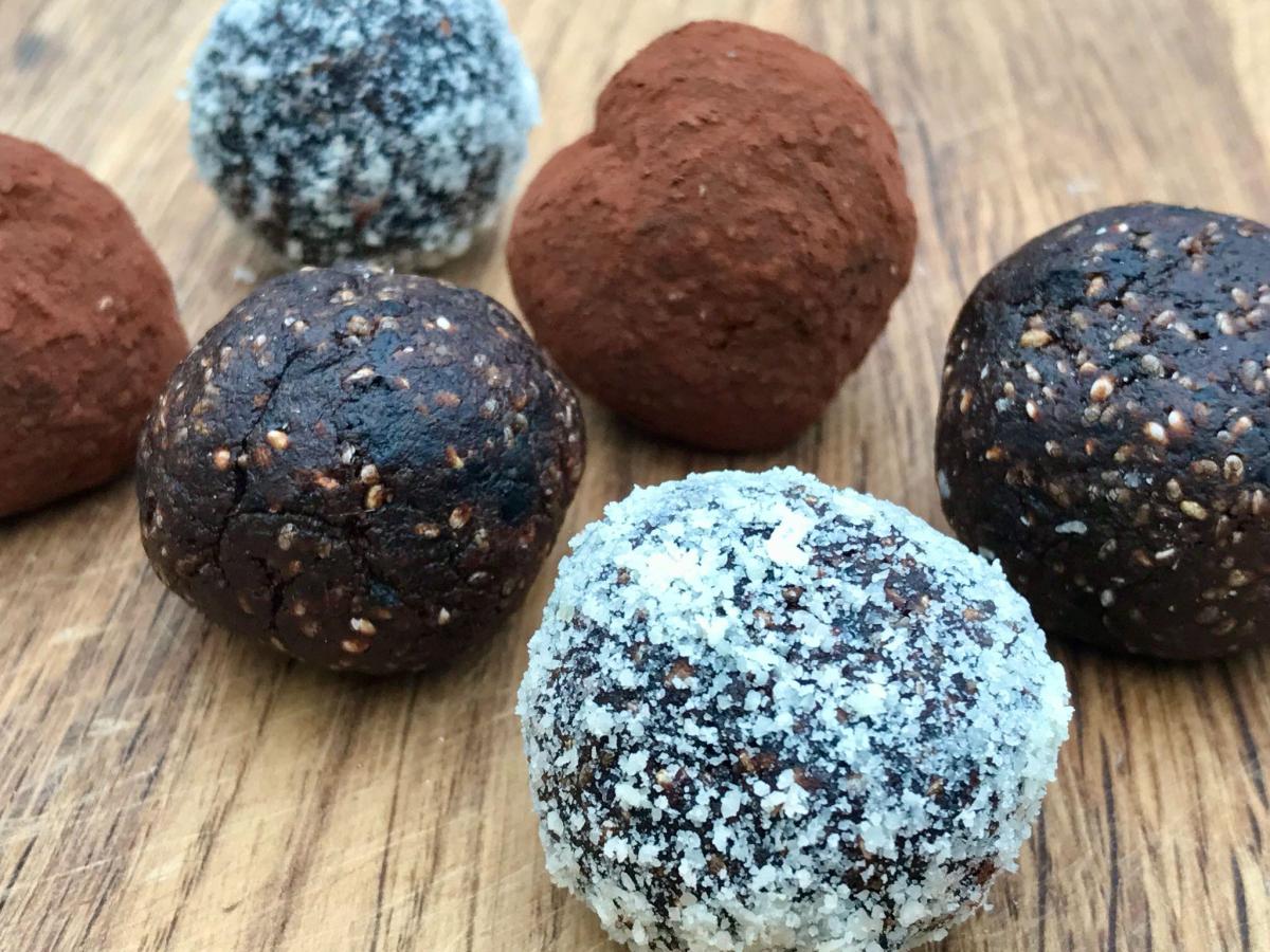 Chocolate bliss balls on wooden board.