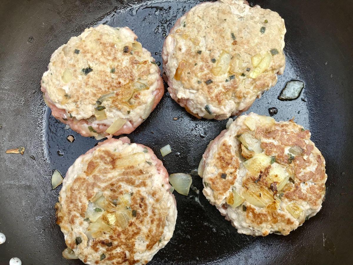 Turkey burgers cooking in pan