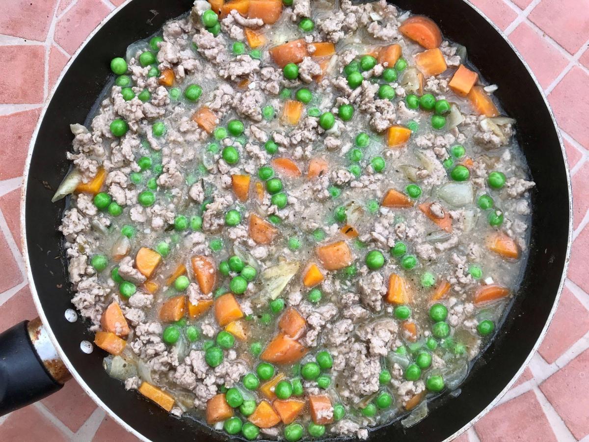 Filling for savoury cobbler in pan with turkey, peas and carrots in pan