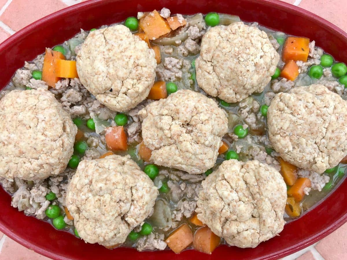 Uncooked turkey cobbler in red baking dish