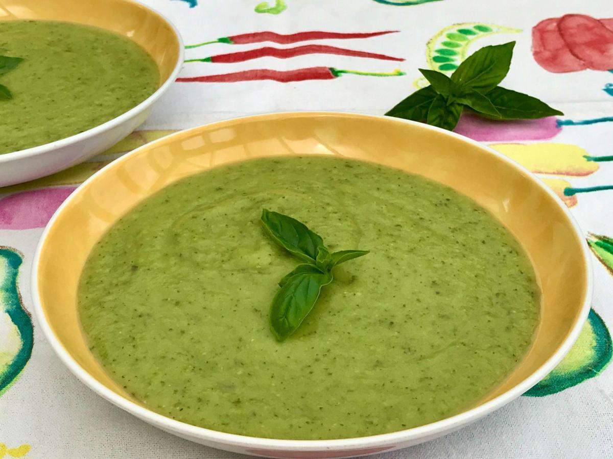 Pea zucchini and basil soup in yellow bowl