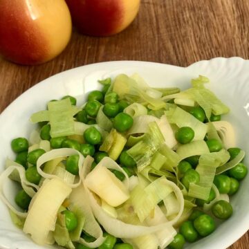 Leeks and peas in white dish.