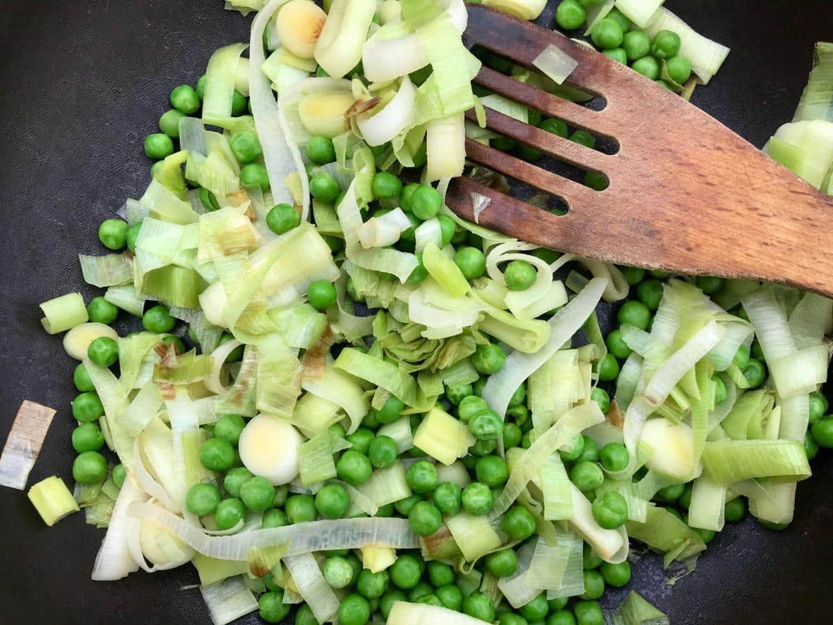 Pan of sauteed peas and leeks.