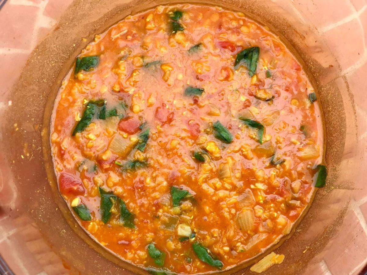 Tomatoes, lentils and herbs in pan.