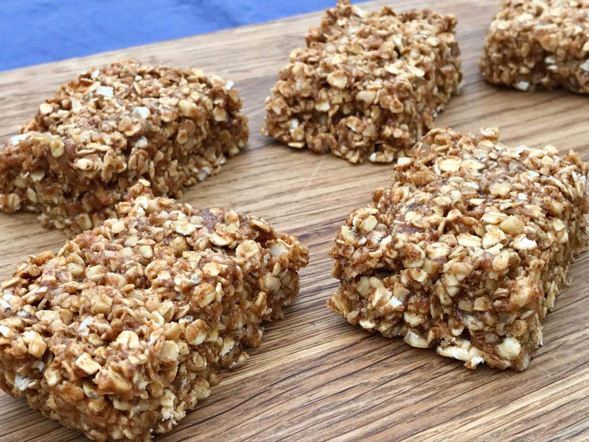 Almond butter granola bars on wooden board.