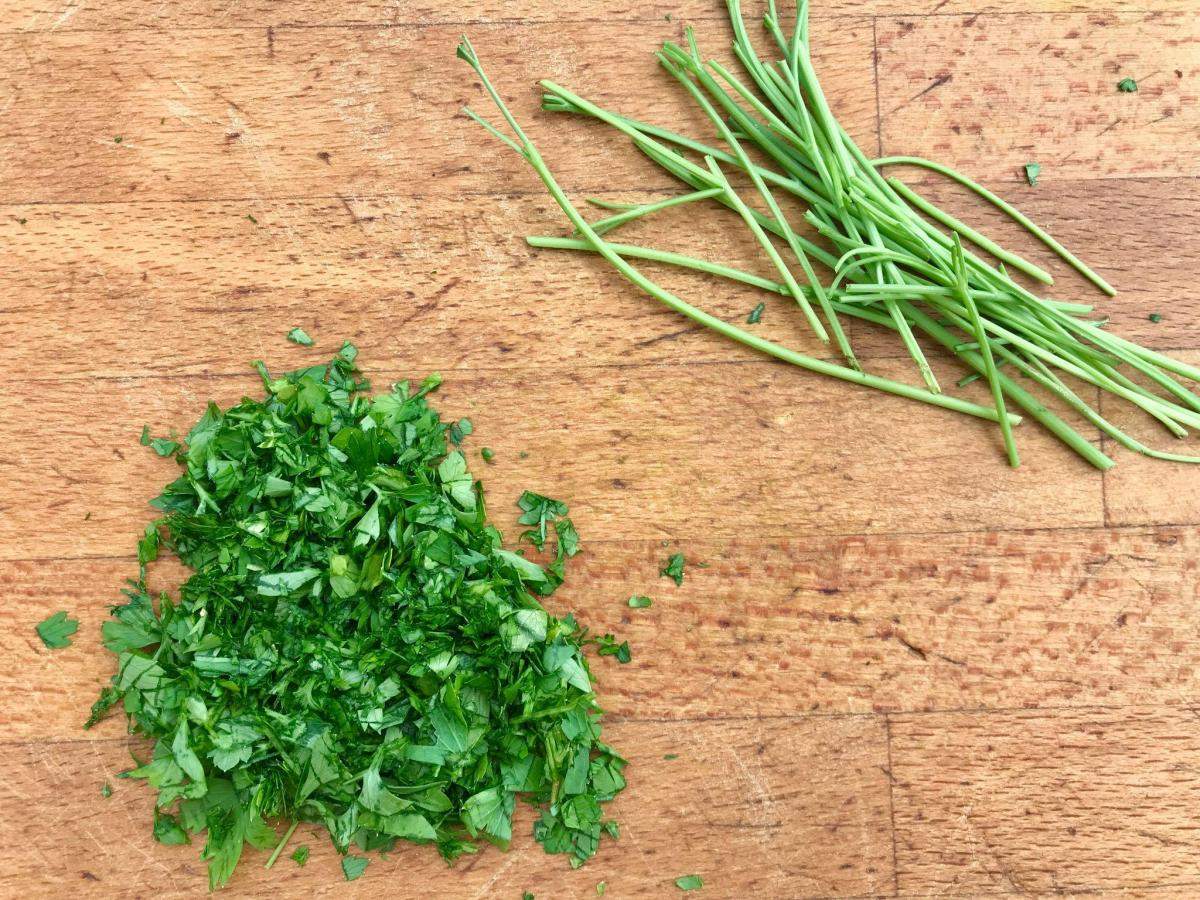 Chopped parsley and stalks on board.