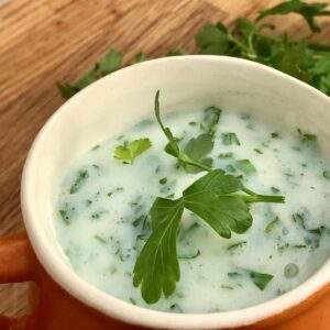 Gluten free parsley sauce in jug with parsley.