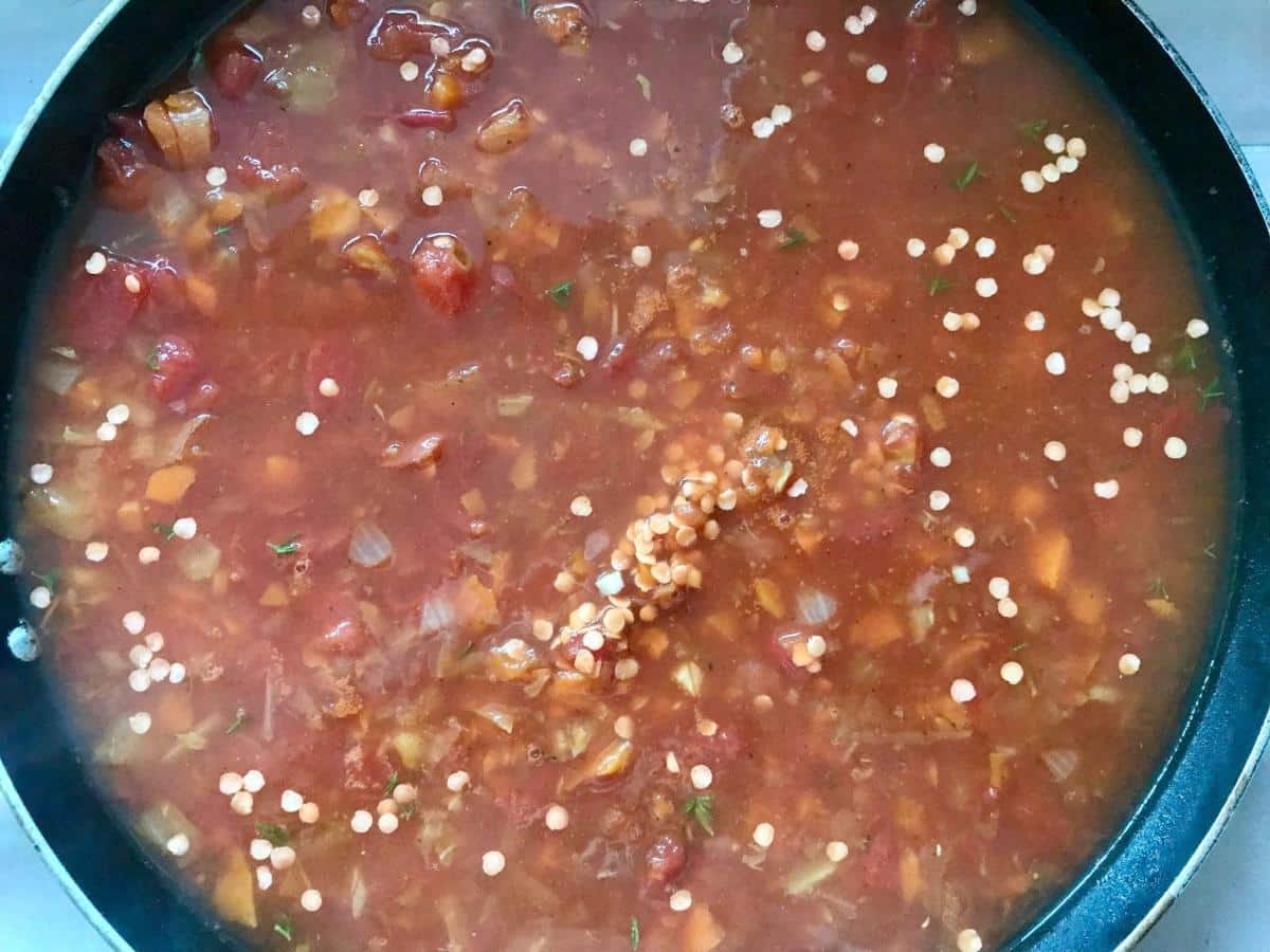 Lentils, stock and vegetables in pan.