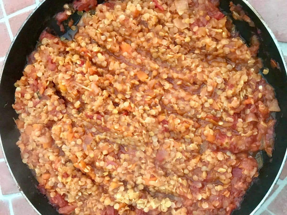 Red lentil bolognese in pan.