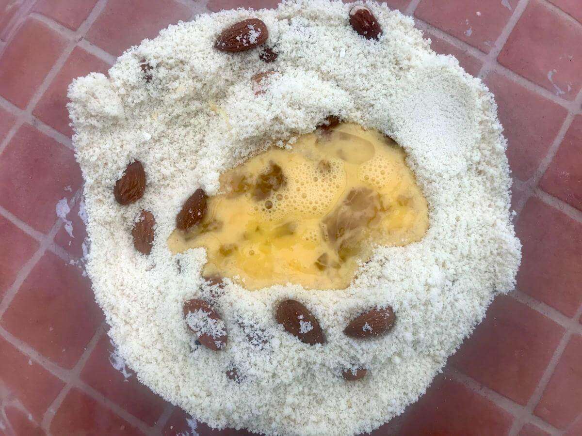 Almonds, coconut flour, eggs and honey in bowl.