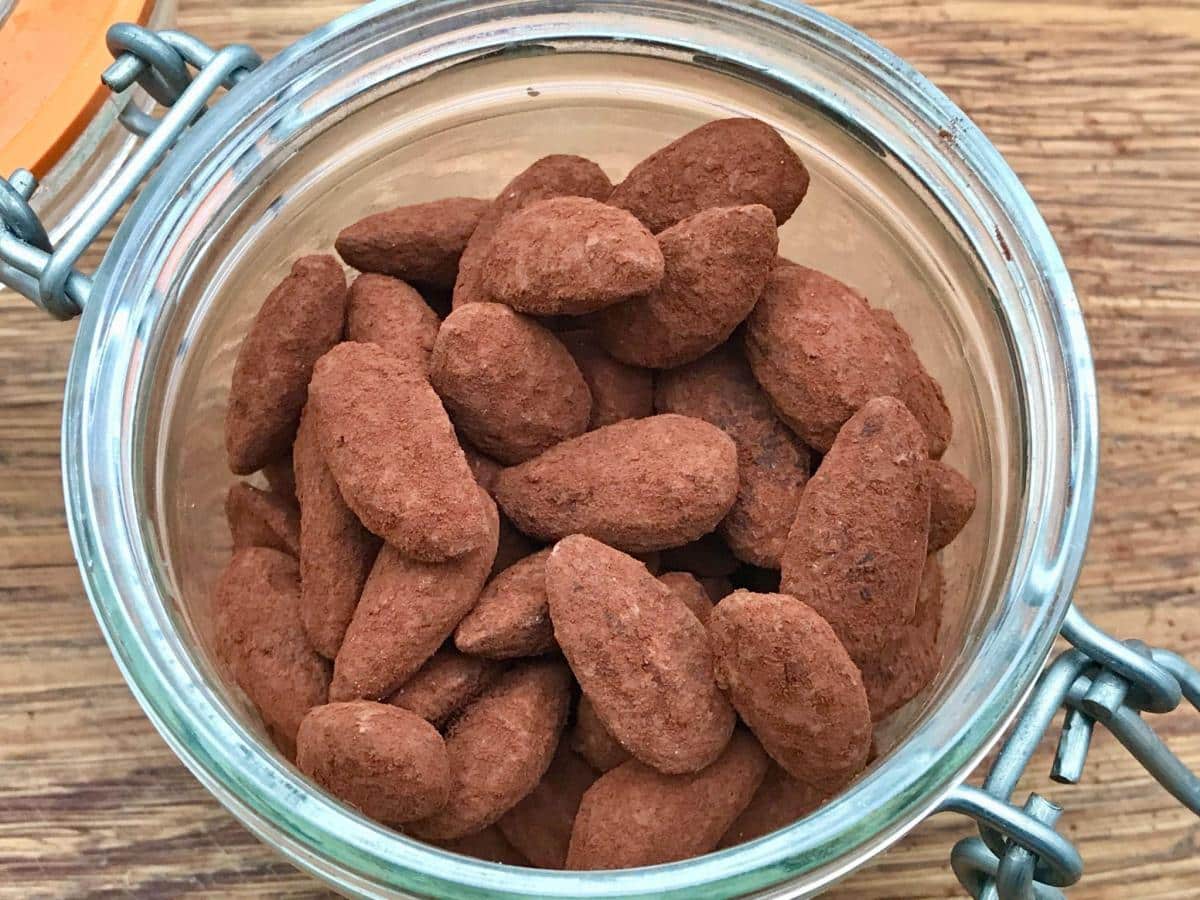 Cocoa dusted almonds in glass jar.