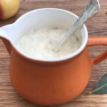 Gluten free bread sauce in brown jug with bay leaf.