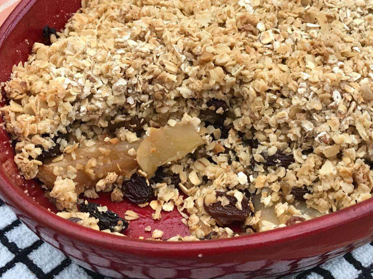 Inside of apple and mincemeat crumble in red dish.