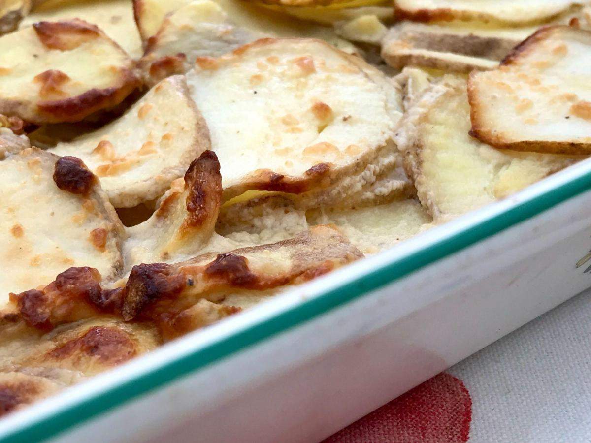 Healthy low fat dauphinoise potatoes in baking dish.