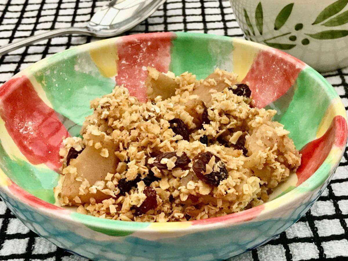 Serving of apple and mincemeat crumble in green bowl.