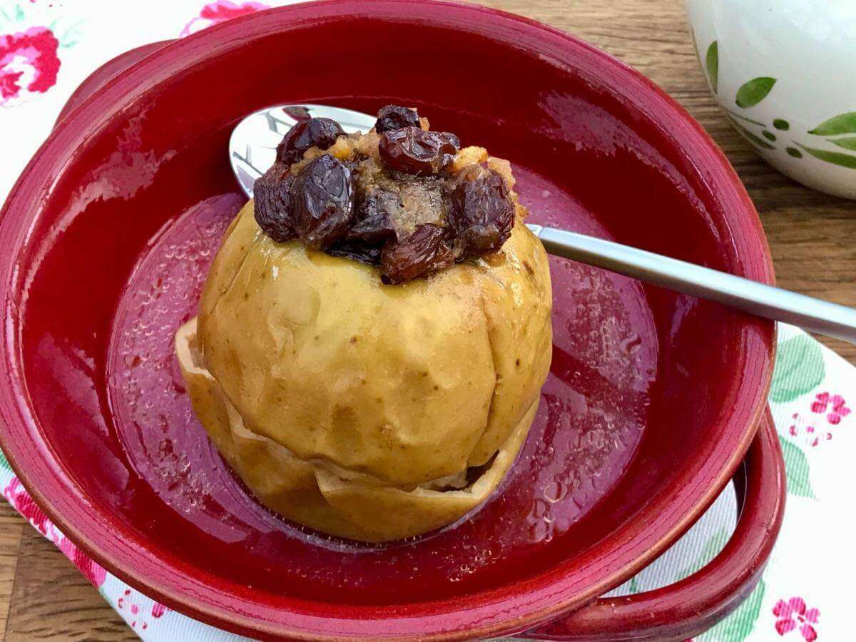 Baked apple with mincemeat in red dish.