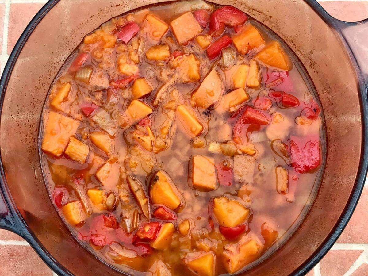 Cooked red pepper and sweet potato in pan.