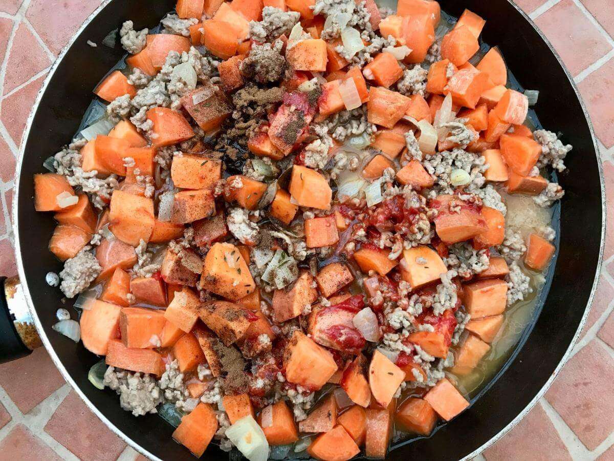 Lamb carrots and sweet potato in pan.