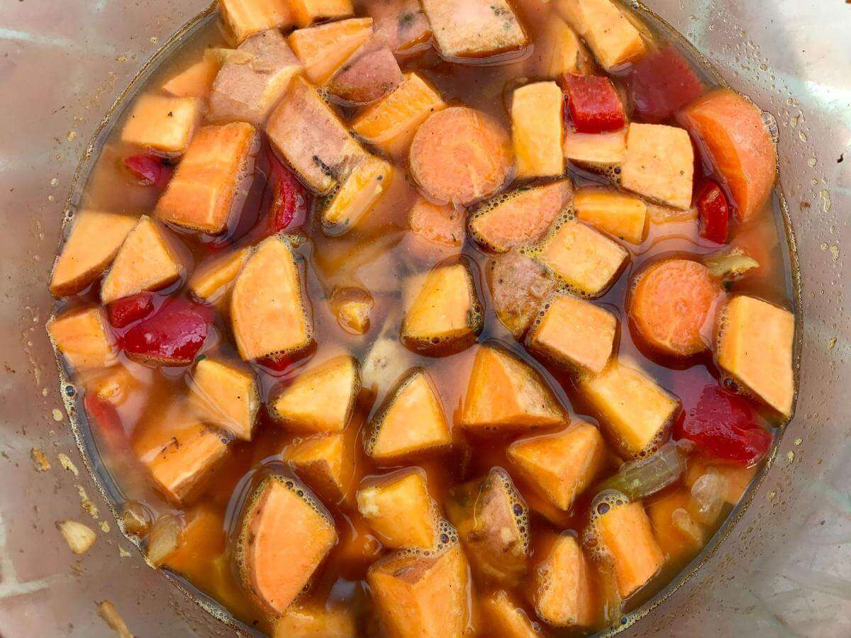 Sweet potato, red pepper and stock in pan.