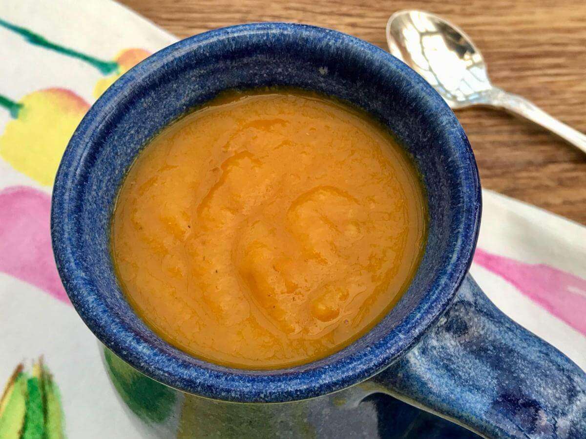 Carrot and swede soup in blue mug.