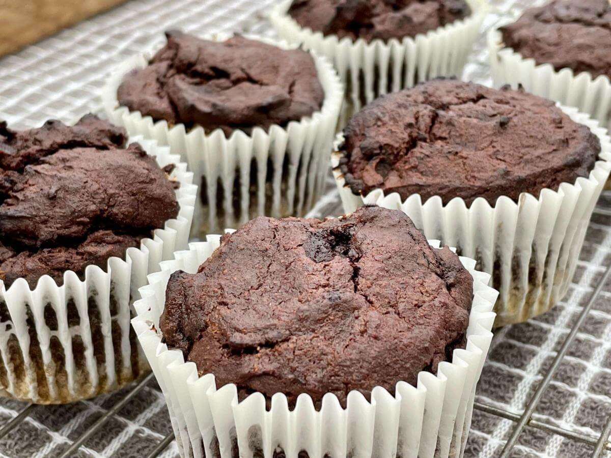 Coconut flour chocolate muffins on wire rack.