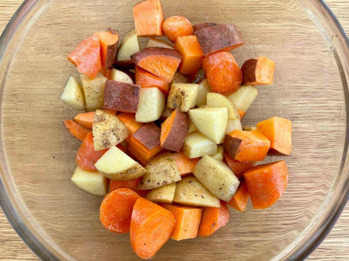 Diced root veg in bowl with oil.