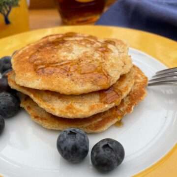 Stack of oat flour pancakes with blueberries.
