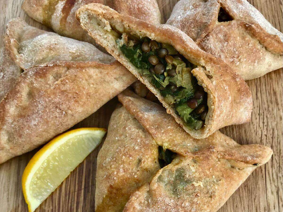 Cut spinach and lentil pasty with slice of lemon.