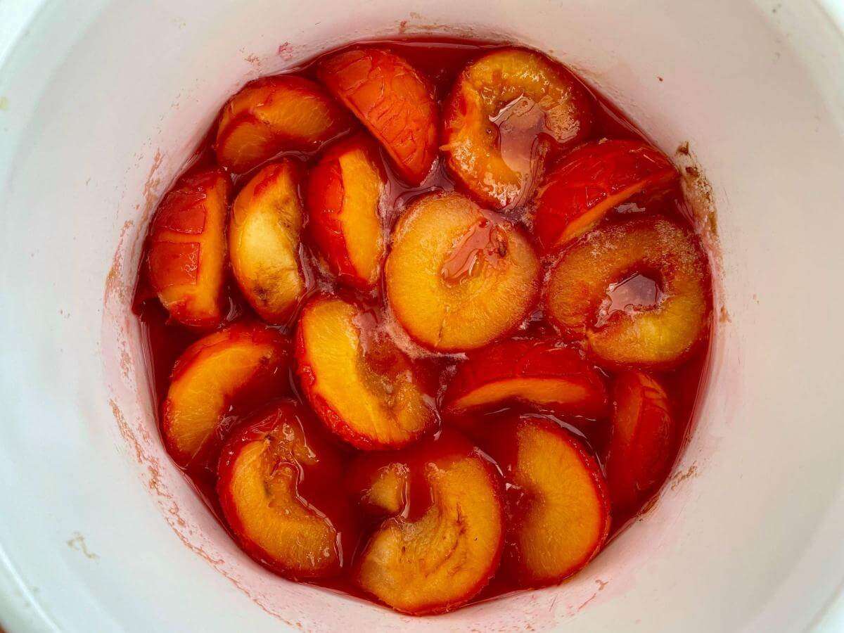 Cooked stewed plums in pan.