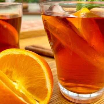 Iced rooibos tea in glass with orange and ice.