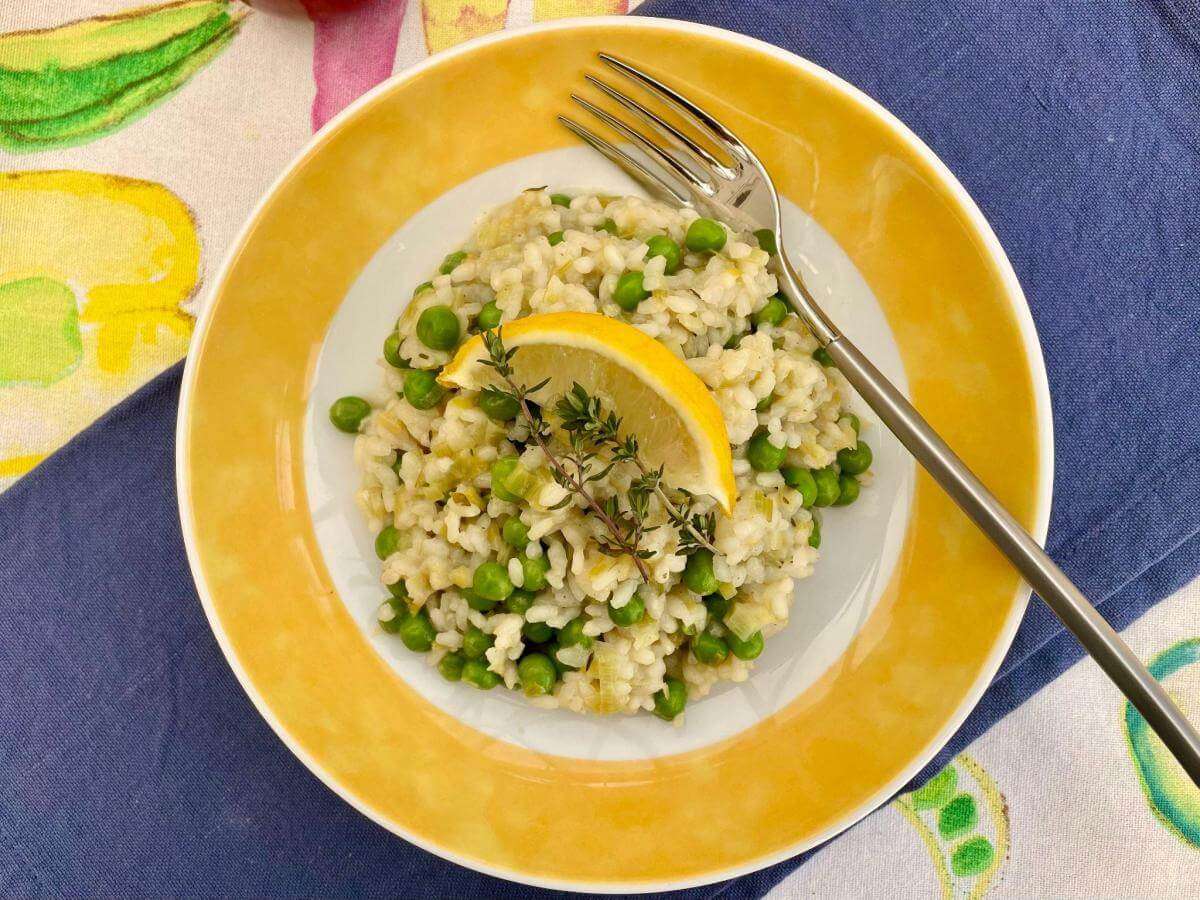 Dairy free leek and pea risotto on yellow plate.