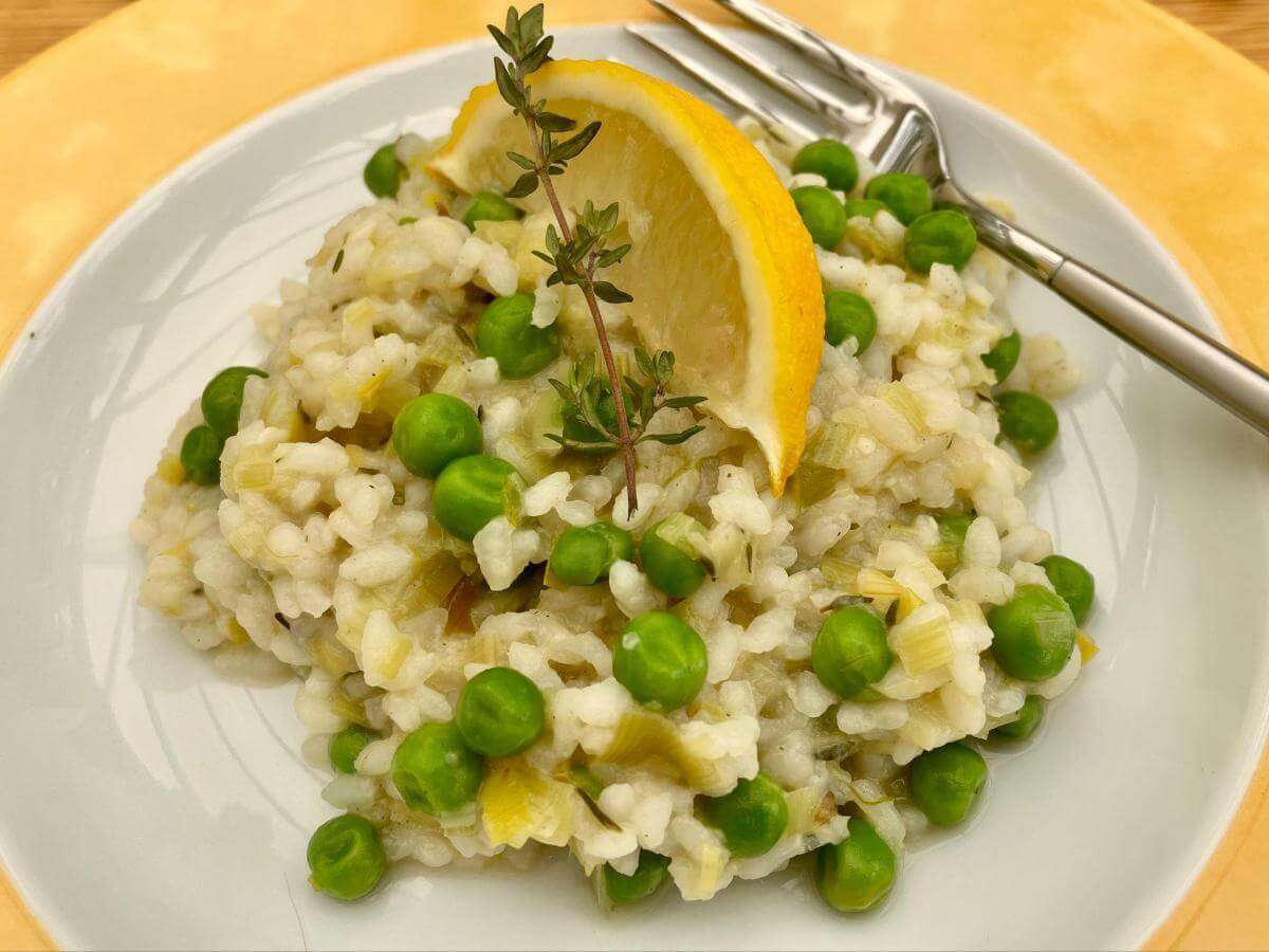 Vegan leek and pea risotto with sprig of thyme.