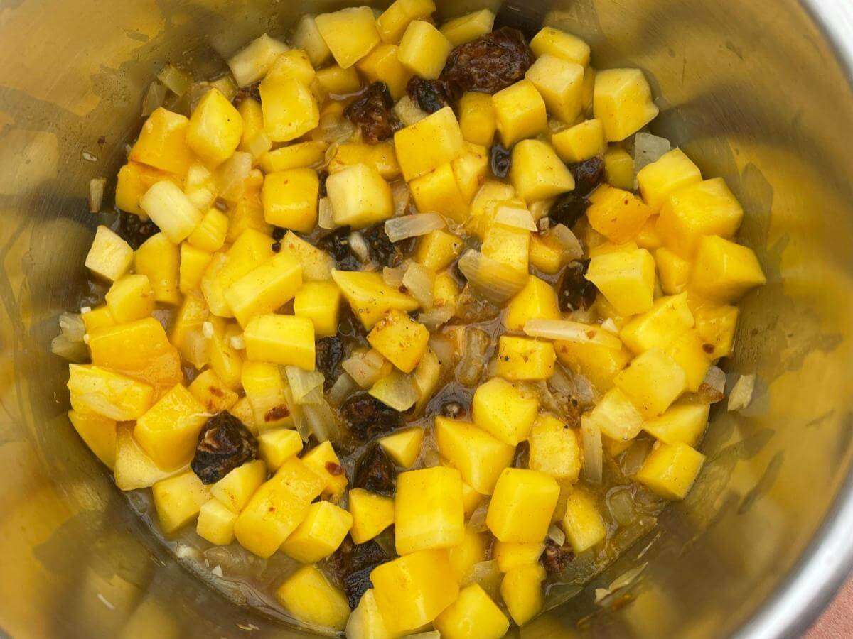 Mango, dates and onion in pan.