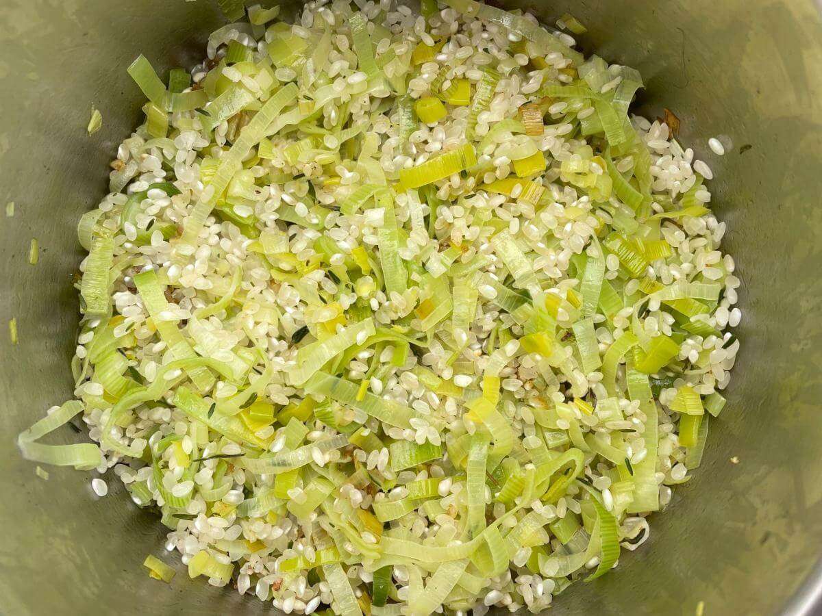 Rice and leeks in pan.