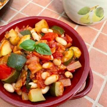 Courgette stew in red dish.