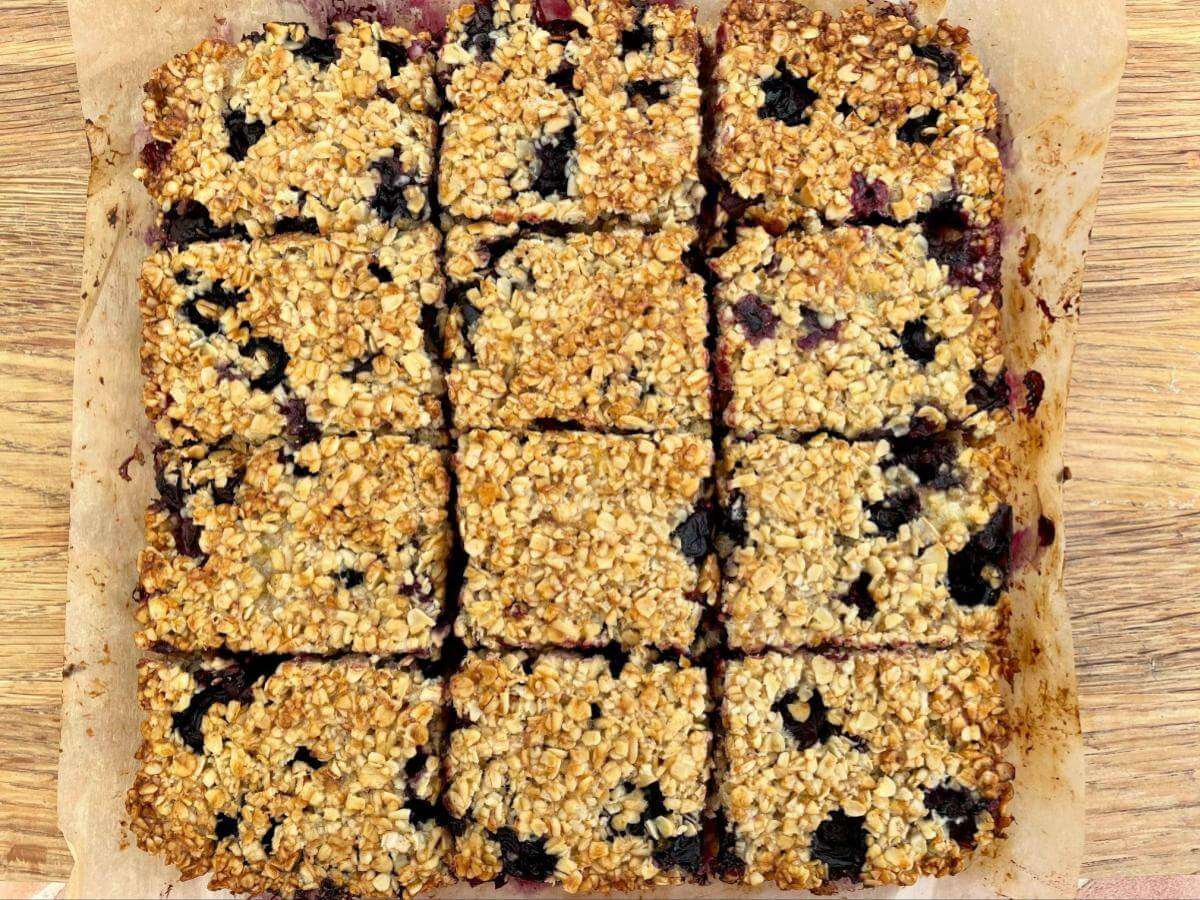 Cut blueberry oat squares on baking paper.