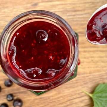 Jar of blackcurrant sauce with spoon.