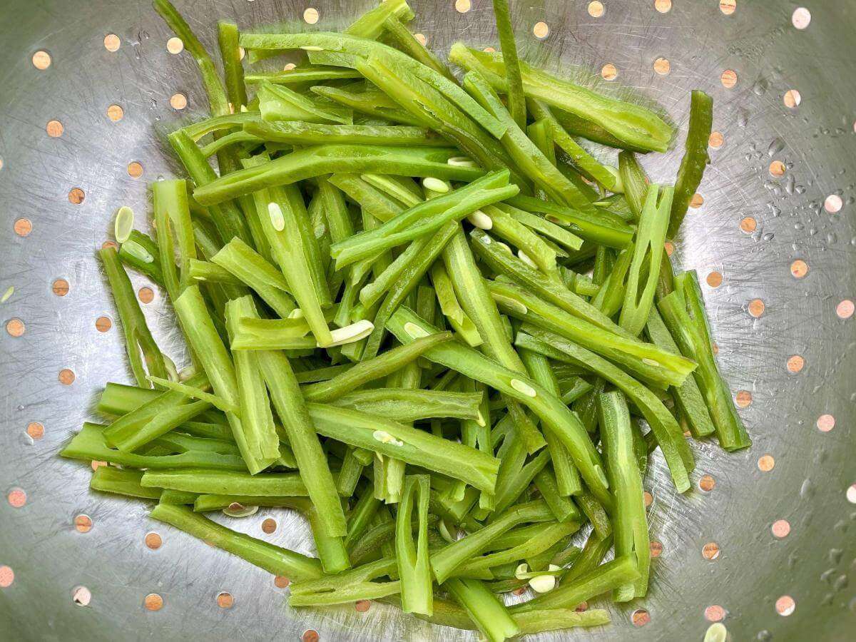 Cooked runner beans in colander.
