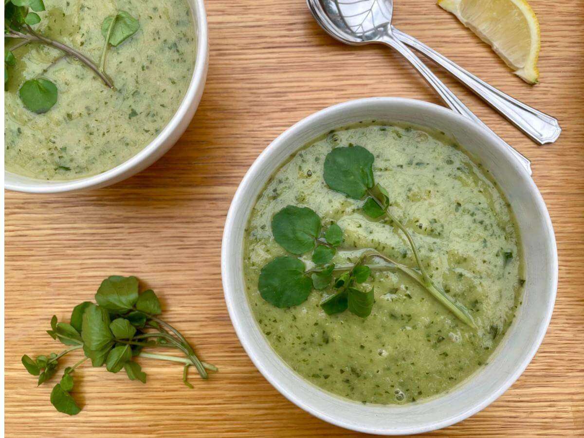 2 bowls of leek and watercress soup with spoons.