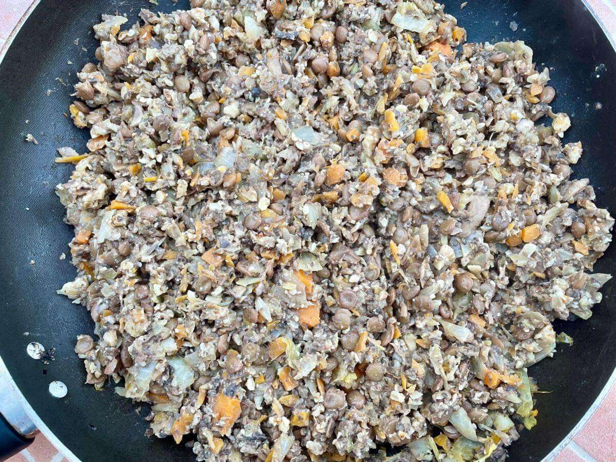 Lentils, mushroom and walnuts in pan.