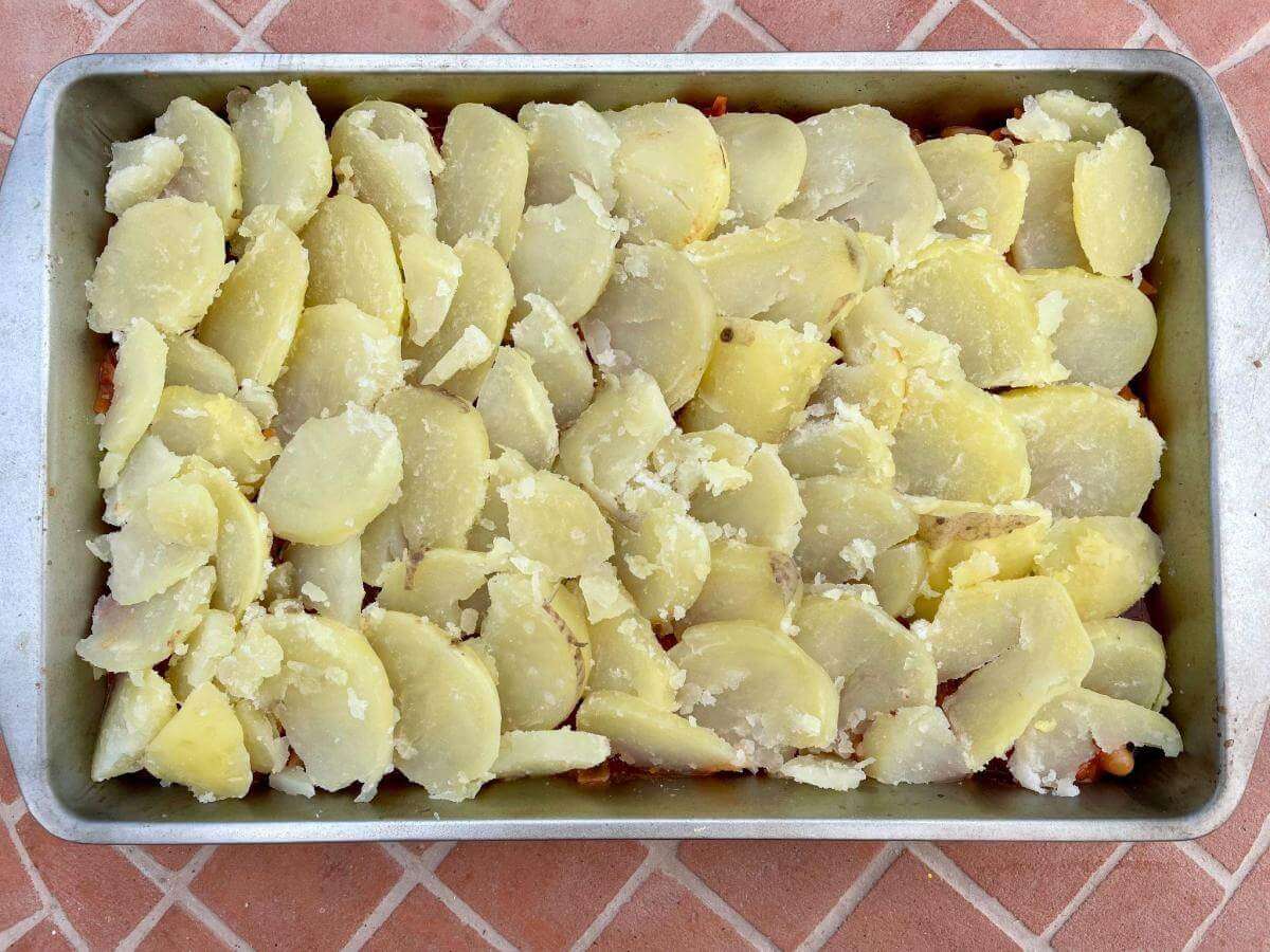 Sliced potatoes on minced beef stew.