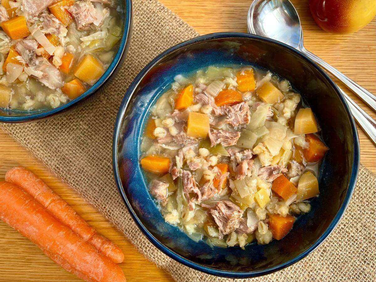 Slow cooker scotch broth in blue bowl.