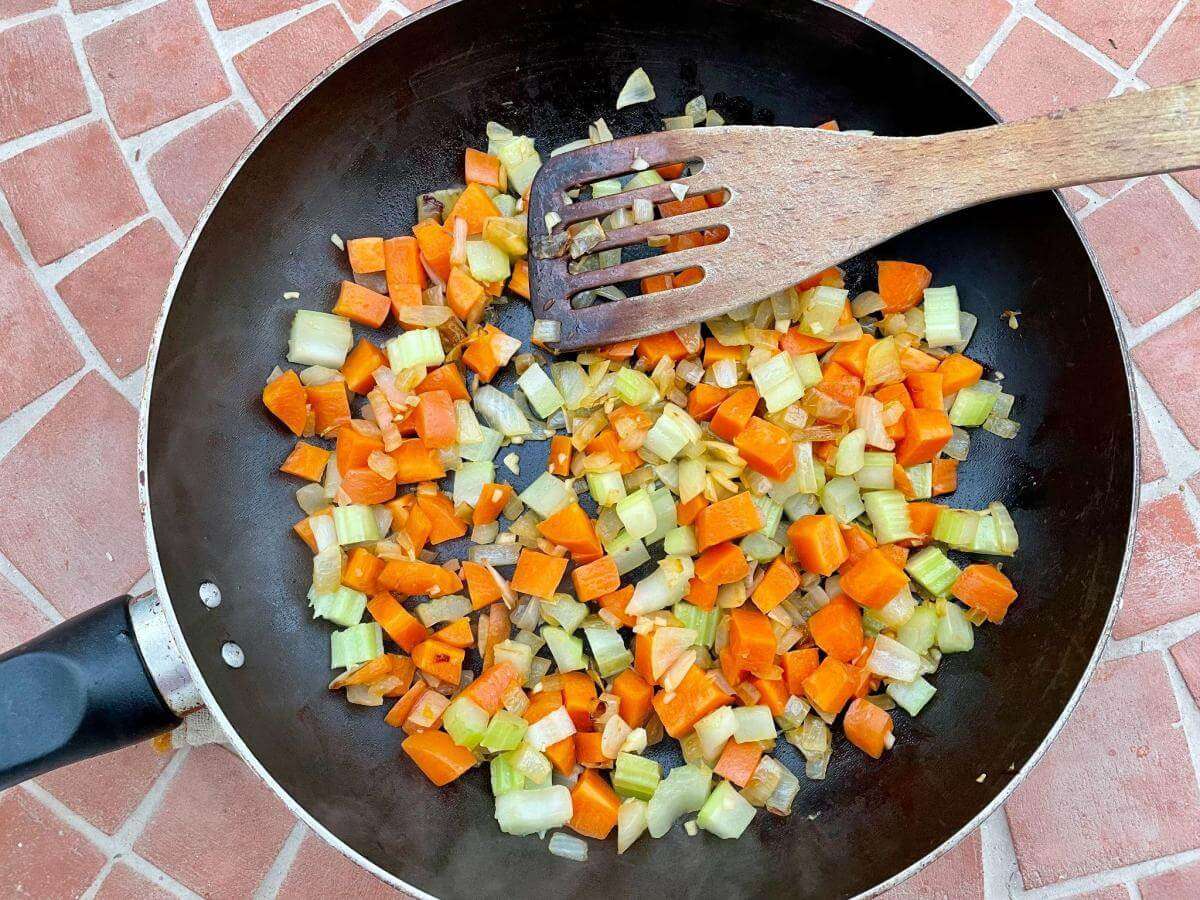 Carrots celery and onion in pan.