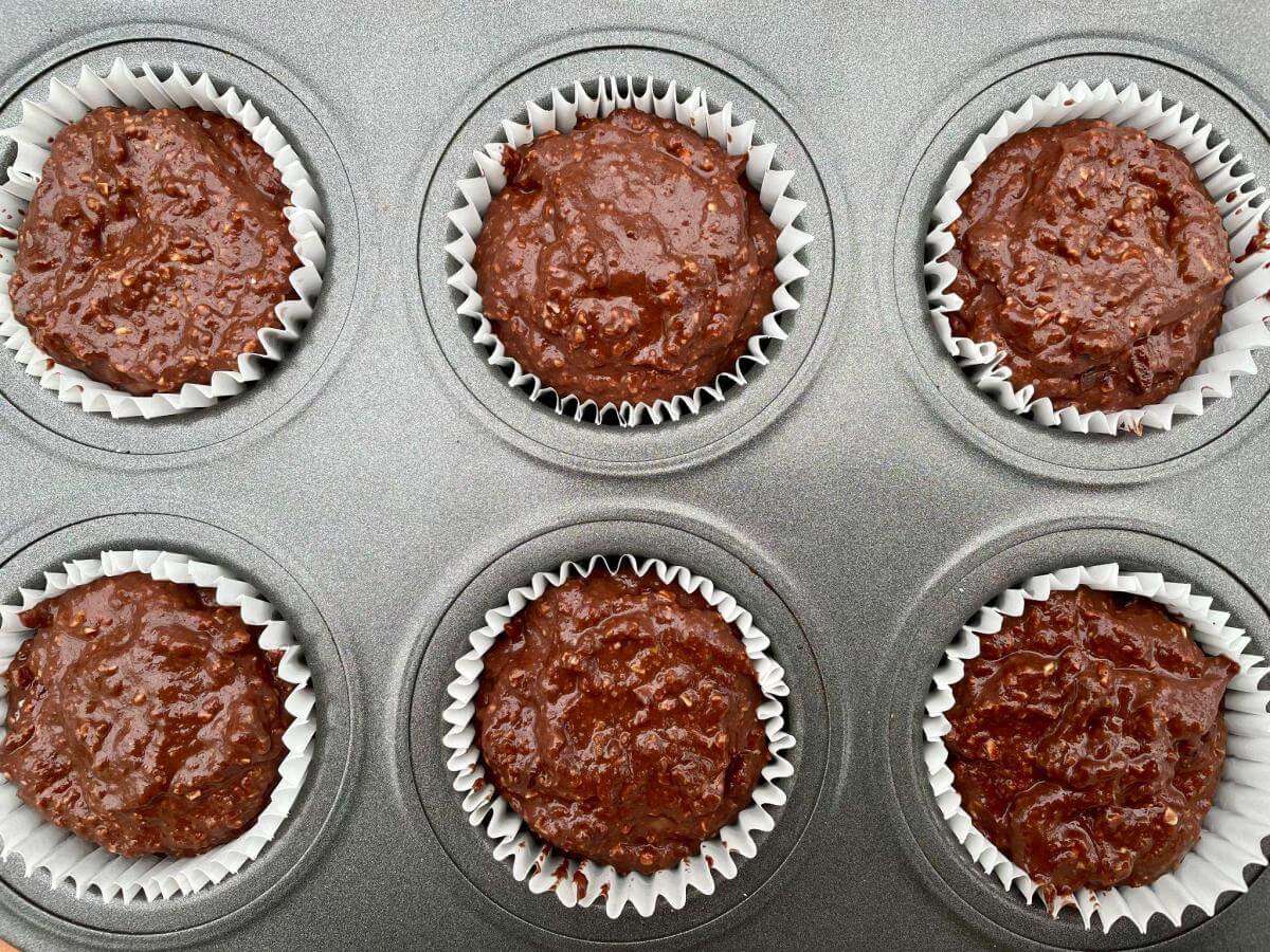Uncooked chocolate muffins in tin.